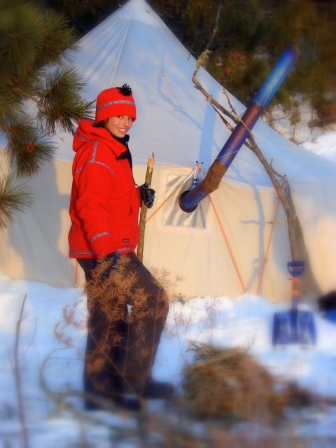 Woman standing outside a snowy tent
