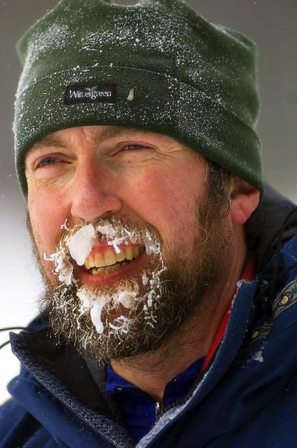 Man in green beanie with snow covering his beard