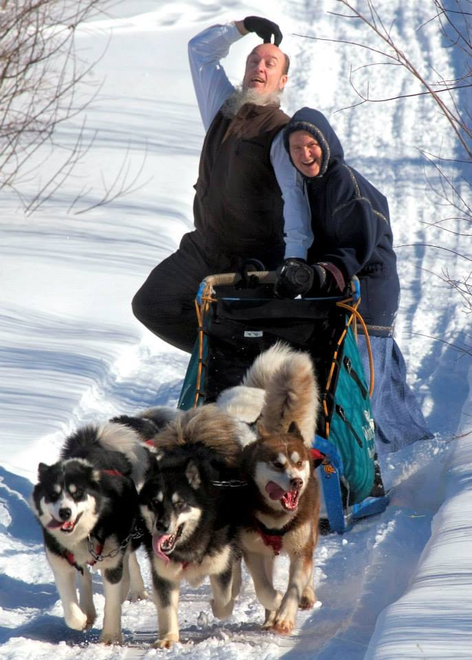 Couple posing being pulled on dog sled