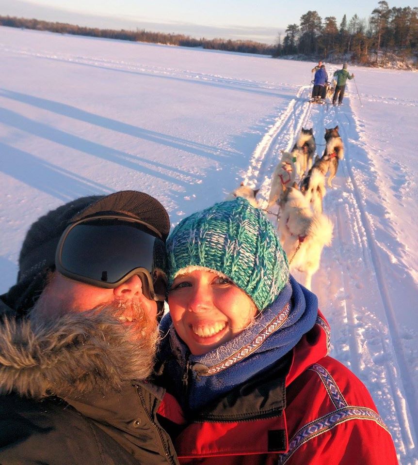 Couple smiling with their sledding dogs